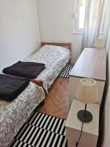 2 letti in una camera con tavolo e lampada di Apartments with WiFi Split - 13120 a Spalato (Split)