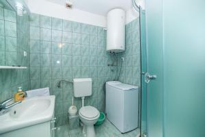 a small bathroom with a toilet and a sink at Apartments with parking space Bol, Brac - 12980 in Bol +15 photos