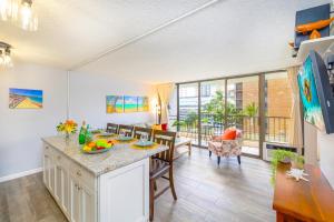 a kitchen and living room with a table and chairs at Remodeled 1BR Condo, Steps to Beach, Free Parking! in Honolulu