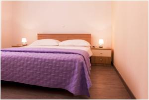 - une chambre avec un lit avec une couverture violette et 2 lampes dans l'établissement Apartments by the sea Kali, Ugljan - 13147, à Kali