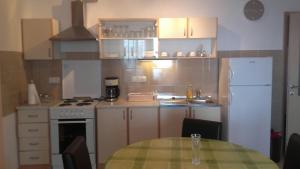 une cuisine avec une table et un réfrigérateur blanc dans l'établissement Apartments by the sea Kali, Ugljan - 13147, à Kali