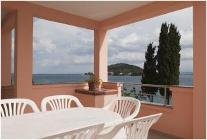 une table et des chaises sur un balcon avec vue sur l'eau dans l'établissement Apartments by the sea Kali, Ugljan - 13147, à Kali 9 autres photos