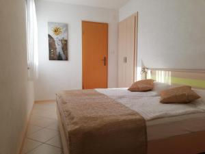 a bedroom with a bed with two pillows on it at Apartments with a parking space Rabac, Labin - 13151 in Rabac