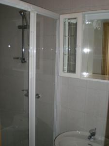 La salle de bains est pourvue d'une douche, d'un lavabo et d'un miroir. dans l'établissement Apartments with a parking space Rabac, Labin - 13151, à Rabac