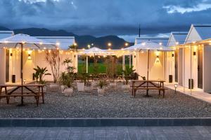 a patio with tables and umbrellas at night at Sun Wild BnB in Sanxing