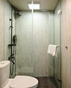a bathroom with a glass shower with a toilet at Sun Wild BnB in Sanxing