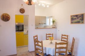 een keuken en eetkamer met een tafel en stoelen bij Apartments with a parking space Novi Vinodolski - 13159 in Novi Vinodolski