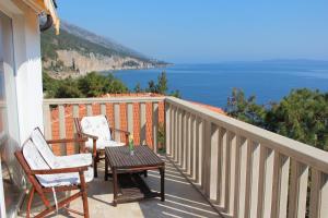 two chairs and a table on a balcony overlooking the ocean at Apartments by the sea Sveta Nedilja, Hvar - 13176 in Jelsa