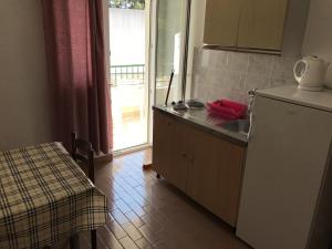 eine Küche mit einem Waschbecken, einem Tisch und einem Fenster in der Unterkunft Apartments and rooms by the sea Gradac, Makarska - 13179 in Gradac