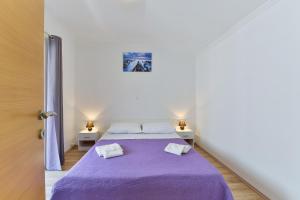 a bedroom with a purple bed with two side tables at Apartment Nin 13172c in Nin