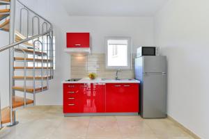 a kitchen with red cabinets and a refrigerator at Apartment Nin 13172c in Nin