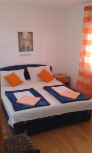 ein Bett mit orangefarbenen und blauen Kissen darauf in der Unterkunft Apartments with a parking space Gradac, Makarska - 13196 in Gradac