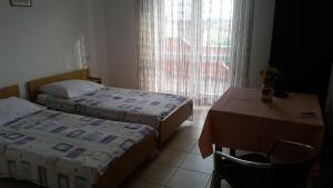 a hotel room with two beds and a table and a table and a tableablish at Apartments with parking space Novalja, Pag - 13200 in Novalja