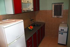 a small kitchen with a sink and a refrigerator at Apartments with parking space Novalja, Pag - 13200 in Novalja +14 photos