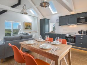 a kitchen and dining room with a table and chairs at The Bothy in Slapton