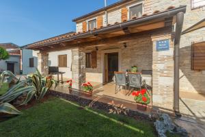 dom z patio z 2 krzesłami i kwiatami w obiekcie Apartments with a parking space Tar, Porec - 13245 w mieście Tar
