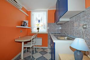 eine kleine Küche mit orangefarbenen Wänden und einem Waschbecken in der Unterkunft Apartments with parking space Porec - 13141 in Poreč + 15 Fotos