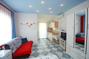 ein Wohnzimmer mit einem roten Sofa und einer Küche in der Unterkunft Apartments with parking space Porec - 13141 in Poreč