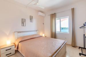 a bedroom with a large bed and a window at Apartments by the sea Karbuni, Korcula - 13217 in Prizba