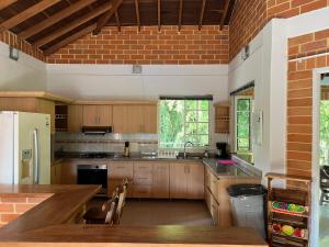 a large kitchen with wooden cabinets and a brick wall at Casa Campestre Veracruz in Pereira