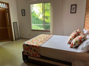 sypialnia z dużym łóżkiem i oknem w obiekcie Casa Campestre Veracruz w mieście Pereira