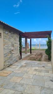 un patio de piedra con un pabellón frente a un edificio en Pé na Areia, en Itapipoca