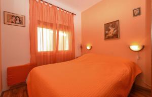 een slaapkamer met een bed met een oranje deken bij Apartments by the sea Guduce, Ugljan - 13274 in Ugljan