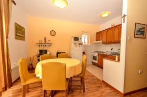 een keuken met een tafel en stoelen en een witte koelkast bij Apartments by the sea Guduce, Ugljan - 13274 in Ugljan
