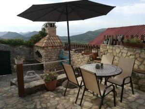 a table and chairs with an umbrella on a patio at Secluded house with a parking space Tomislavovac, Peljesac - 13280 in Putniković