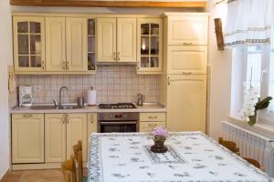 a kitchen with yellow cabinets and a table with flowers on it at Apartments with a parking space Zagore, Opatija - 13277 in Mošćenička Draga