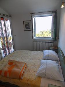 a bedroom with a bed with two pillows and a window at Apartments with a parking space Zagore, Opatija - 13277 in Mošćenička Draga