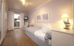 a bedroom with a bed and a table with a lamp at Hotel Föhrenhof Garni in Farchant