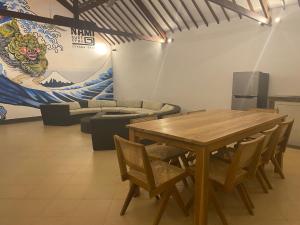 a dining room with a wooden table and chairs at Nami Surf Stay in Canggu
