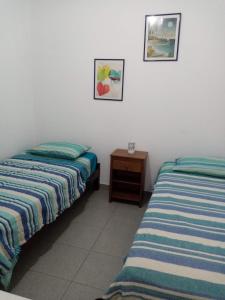 two beds sitting next to each other in a room at Departamentos Cerro Azul P2 in Cerro Azul