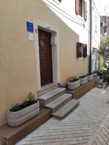 a building with stairs leading to a brown door at Apartments by the sea Cres - 13312 in Cres