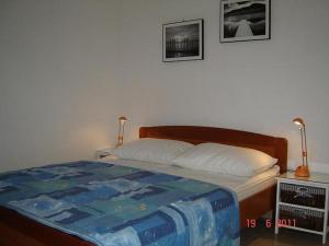 ein Schlafzimmer mit einem Bett und zwei Bildern an der Wand in der Unterkunft Apartments by the sea Brgulje, Molat - 13318 in Molat