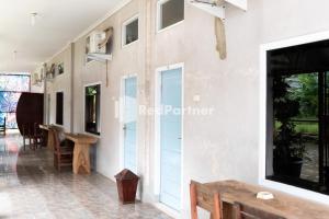 班達楠榜的住宿－Pondok Kelapa Homestay Lampung Mitra RedDoorz，一间设有蓝色门和一张桌子的墙壁的房间