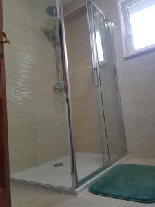 La salle de bains est pourvue d'une douche avec une porte en verre. dans l'établissement Apartments by the sea Kastel Kambelovac, Kastela - 13349, à Kaštela