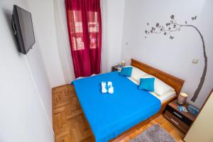 niewielka sypialnia z niebieskim łóżkiem i oknem w obiekcie Apartments with a parking space Split - 13347 w Splicie