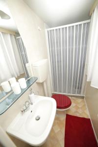 a bathroom with a white sink and a red toilet at Family friendly apartments with a swimming pool Bol, Brac - 13364 in Bol