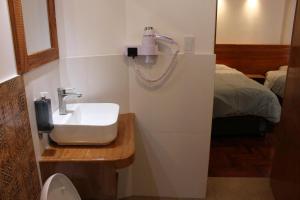baño con lavabo y cama en Akilpo Home, en Huaraz