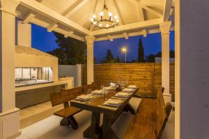 a dining table on an outdoor patio at night at Luxury villa with a swimming pool Split - 13408 in Split