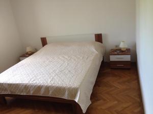 a bedroom with a bed and two night stands with lamps at Apartments by the sea Muline, Ugljan - 12533 in Ugljan