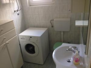 un piccolo bagno con lavatrice e lavandino di Apartments by the sea Muline, Ugljan - 12533 a Ugljan (Ugliano)