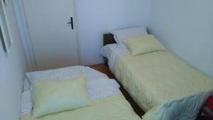 2 camas en una habitación pequeña con una cruz en la pared en Apartments with a parking space Klis, Split - 13435, en Klis