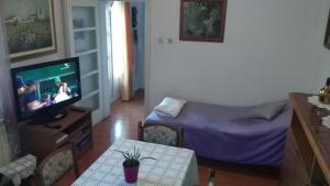 Una sala de estar con un televisor y una mesa. en Apartments with a parking space Klis, Split - 13435, en Klis