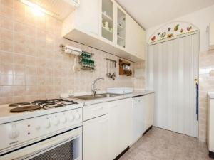 eine weiße Küche mit Herd und Spüle in der Unterkunft Apartments with a parking space Kastav, Opatija - 13441 in Kastav