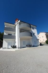 a white building with chairs in front of it at Apartments with a parking space Kastav, Opatija - 13457 in Kastav