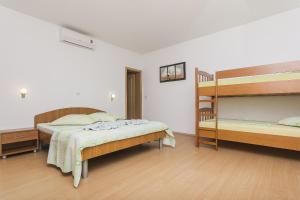 een slaapkamer met 2 bedden en een stapelbed bij Apartments with a parking space Brela, Makarska - 11687 in Brela