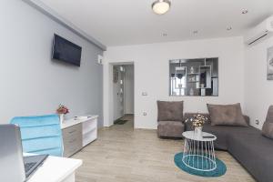 un soggiorno con divano e tavolo di Apartments with a parking space Brela, Makarska - 11687 a Brela